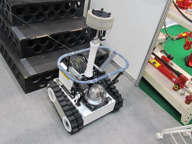 トピー工業のブース。福島原発内に投入された災害対策ロボット「Survey Runner」。現在、原発内で回収不能となっているが、新しいロボットを投入すべく準備を進めている