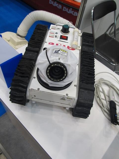 トピー工業のブース。床下点検ロボット「Anie s90」。コンクリートの亀裂などを測定したり、撮影した一連の写真を貼り付けて報告書を作成できる