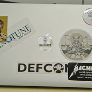 名刺交換後、柳下氏のノートPCのステッカーを接写。DEF CON やShinoBOTなどに混じって、ケビン・ベーコン主演の映画「コップカー」のステッカーが。。